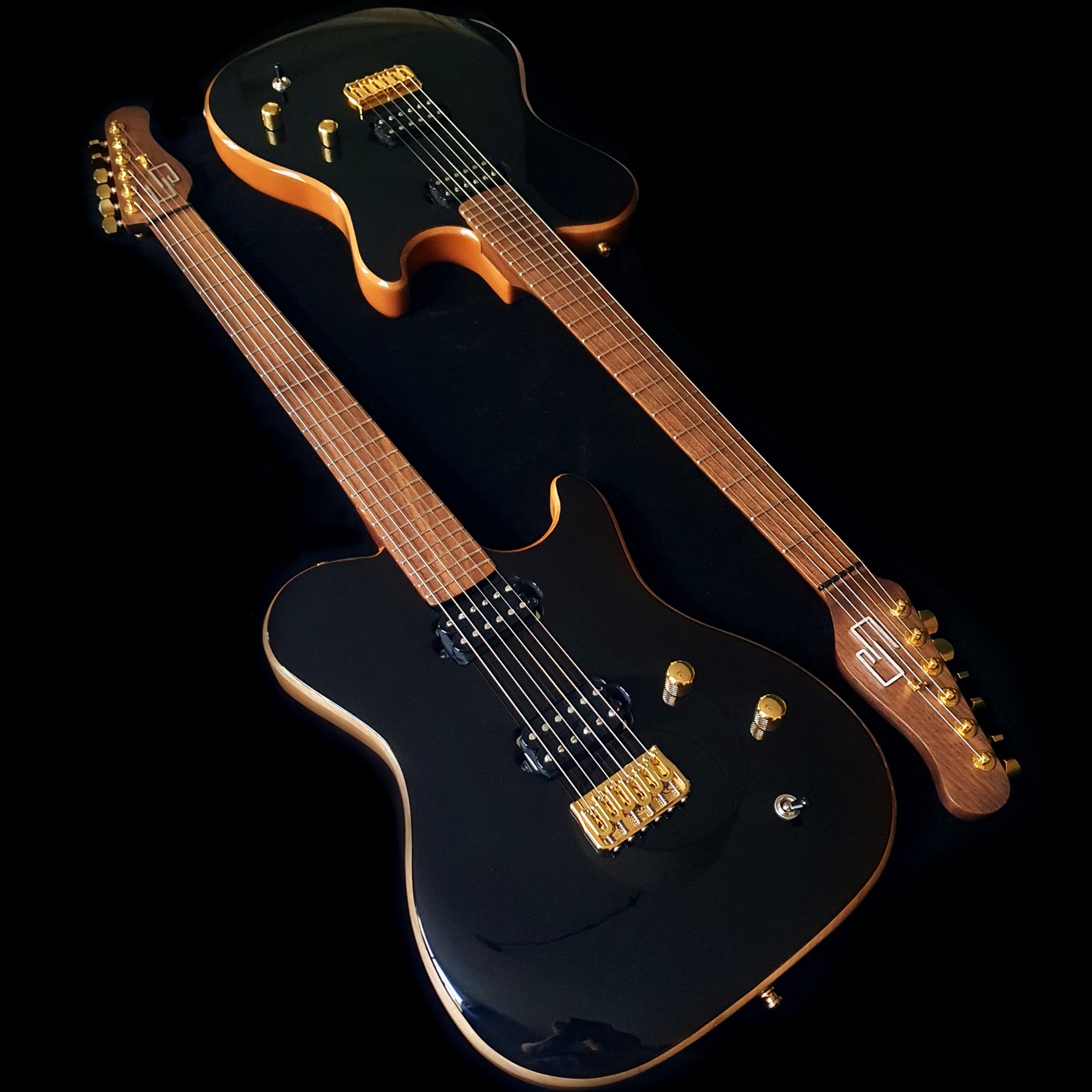 Two black Core Guitars Persephone electric guitars with gold hardware
